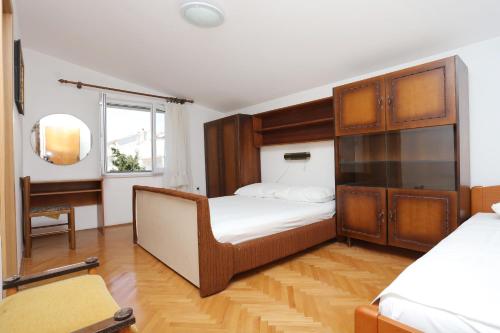 a bedroom with a bed and a dresser in it at Apartments with a parking space Makarska - 9506 in Makarska