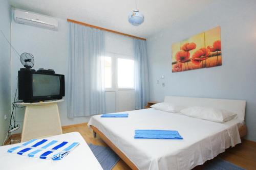 1 dormitorio con 1 cama y TV. en Apartment Orebic 10256b en Orebić