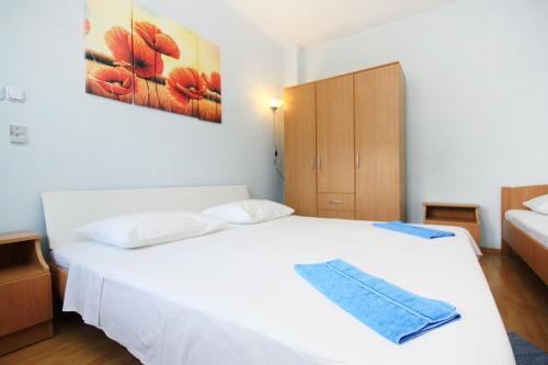 Un dormitorio con una cama blanca con una toalla azul. en Apartment Orebic 10256b en Orebić