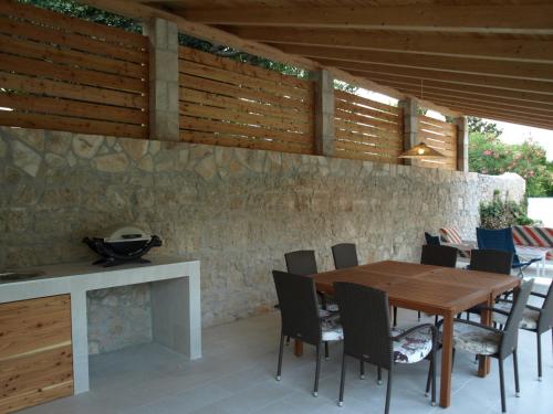 ein Esszimmer mit einem Holztisch und Stühlen in der Unterkunft Apartments by the sea Orebic, Peljesac - 10153 in Orebić
