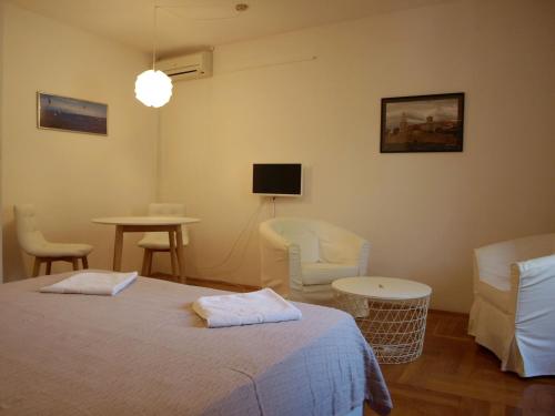 a bedroom with a bed and chairs and a tv at Apartment Orebic 10153f in Orebić