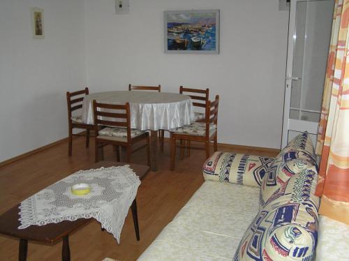 ein Wohnzimmer mit einem Tisch, Stühlen und einem Sofa in der Unterkunft Apartments with a parking space Orebic, Peljesac - 10096 in Orebić