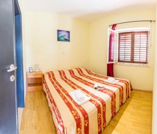 a bedroom with a bed with a red and yellow blanket at Apartment Zuronja 10134b in Brijesta