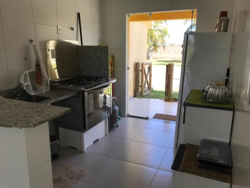 a kitchen with a stove and a refrigerator at Villa das aguas -Praia do saco -Próximo as lagoas dos Tambaquis e Mangue Seco -térreo in Estância