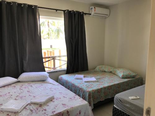 Un pat sau paturi într-o cameră la Villa das aguas -Praia do saco -Próximo as lagoas dos Tambaquis e Mangue Seco -térreo