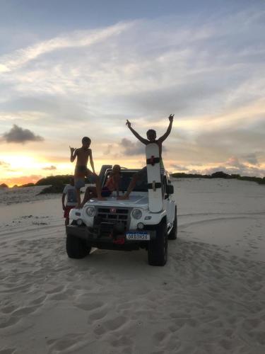 a group of people riding in a jeep on the beach at Villa das aguas -Praia do saco -Próximo as lagoas dos Tambaquis e Mangue Seco -térreo in Estância