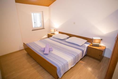 una camera da letto con un letto e un asciugamano viola di Apartments by the sea Zubovici, Pag - 9678 a Zubovići