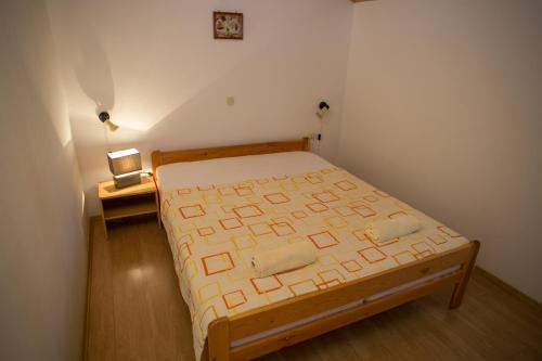 a bedroom with a bed with a wooden frame at Apartments by the sea Zubovici, Pag - 9678 in Zubovići