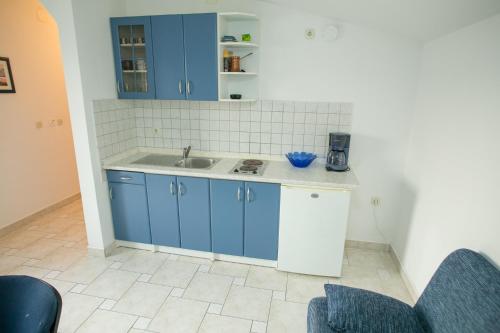 una cucina con armadi blu e lavandino di Apartments by the sea Zubovici, Pag - 9678 a Zubovići