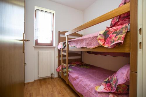 um quarto com 2 beliches e uma janela em Apartments for families with children Presika, Labin - 11656 em Labin