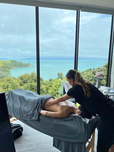 a woman giving a man a massage in a bed at Omana in Rocky Bay