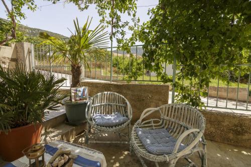 Dos sillas y una mesa en un patio. en Apartments by the sea Komiza, Vis - 11671, en Komiža