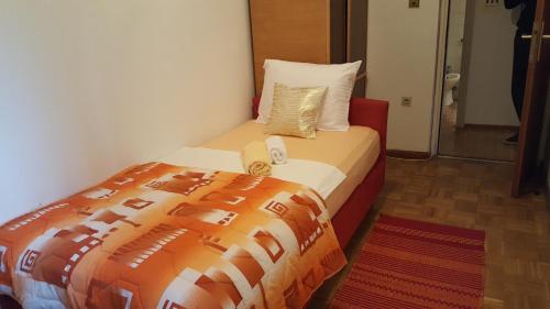 a bedroom with a bed with an orange comforter at Apartments with WiFi Split - 11680 in Split
