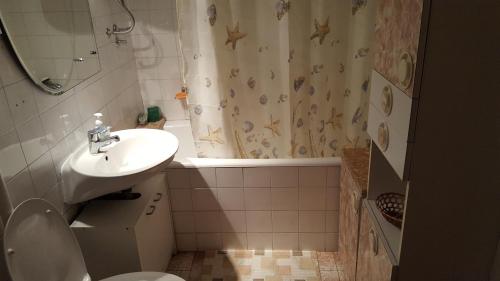 a bathroom with a sink and a toilet and a shower curtain at Apartments with WiFi Split - 11680 in Split