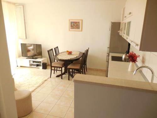 a kitchen and dining room with a table and a refrigerator at Apartments with WiFi Split - 11692 in Split