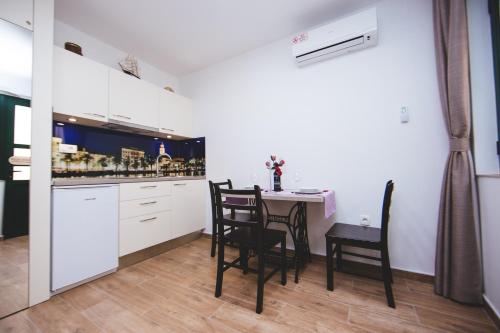 a kitchen with a table and chairs in a room at Apartments with a parking space Split - 11690 in Split