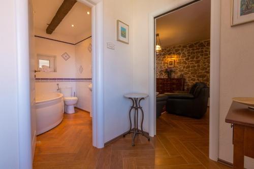 a bathroom with a tub and a toilet and a sink at Apartments by the sea Selce, Crikvenica - 11693 in Selce