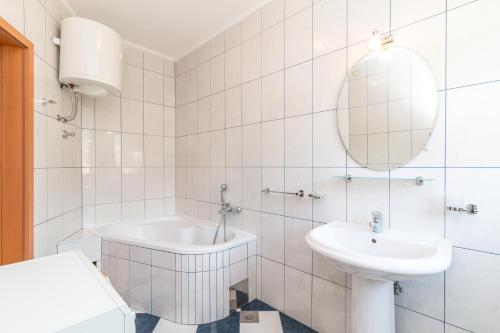 ein weißes Badezimmer mit einem Waschbecken und einer Badewanne in der Unterkunft Apartments with a parking space Kastel Kambelovac, Kastela - 11678 in Kaštela