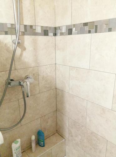 une salle de bain avec une douche avec pommeau de douche dans l'établissement KIEVAILLE, à Plaisir