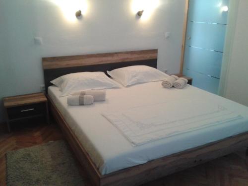 a bedroom with a bed with two white towels on it at Apartments by the sea Vranjic, Split - 11753 in Vranjic