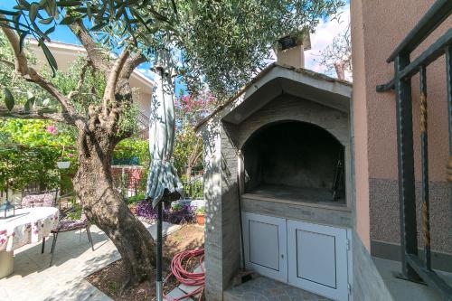 a outdoor pizza oven next to a tree at Apartment Podaca 11748a in Podaca