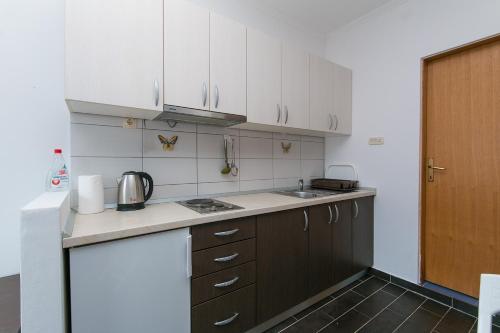 a kitchen with white cabinets and a sink at Apartment Podaca 11748a in Podaca