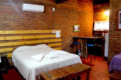 1 dormitorio con 1 cama con toallas en CABAÑAS SOLTAME CARNAVAL en Puerto Iguazú