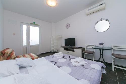 Schlafzimmer mit einem Bett, einem Schreibtisch und einem TV in der Unterkunft Studio Podaca 11748a in Podaca