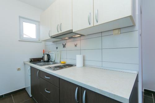 eine Küche mit weißen Schränken und einer Arbeitsplatte in der Unterkunft Studio Podaca 11748a in Podaca
