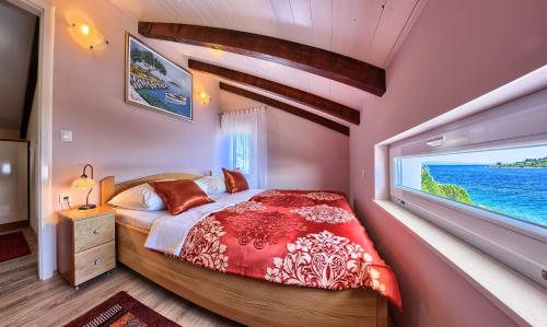 een slaapkamer met een groot bed en een groot raam bij Seaside luxury villa with a swimming pool Cove Siroka, Ciovo - 11749 in Trogir