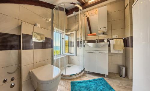 een badkamer met een toilet, een wastafel en een douche bij Seaside luxury villa with a swimming pool Cove Siroka, Ciovo - 11749 in Trogir