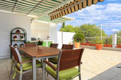 a patio with a wooden dining table and chairs at Apartments with WiFi Split - 11783 in Split