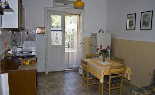 a kitchen with a table and a refrigerator and a table and chairs at Apartments with WiFi Split - 11667 in Split