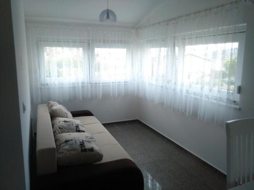 a living room with a couch and two windows at Apartments by the sea Pag - 11778 in Pag