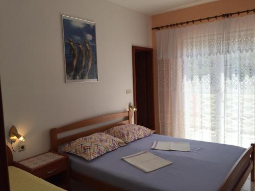a bedroom with a blue bed with a window at Apartments by the sea Lun, Pag - 11781 in Lun