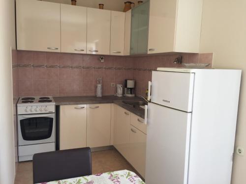 eine Küche mit weißen Geräten und einem weißen Kühlschrank in der Unterkunft Apartments by the sea Lun, Pag - 11781 in Lun