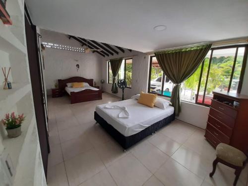 a bedroom with a bed and a large window at Casa campestre melgar herradura con piscina privada in Melgar