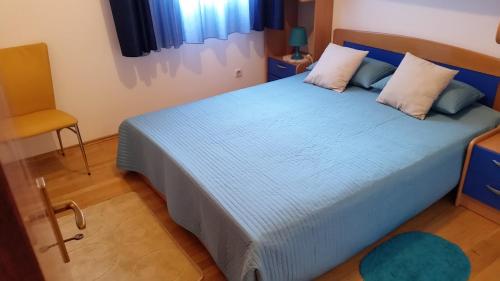 a bedroom with a blue bed and a yellow chair at Apartments with WiFi Split - 11784 in Split