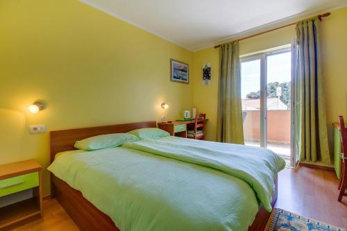sypialnia z dużym łóżkiem i dużym oknem w obiekcie Apartments and rooms by the sea Nerezine, Losinj - 11815 w mieście Nerezine