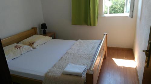 Schlafzimmer mit einem Bett und einem Fenster sowie einem Bett sidx sidx sidx in der Unterkunft Apartments with a parking space Vir - 11812 in Vir