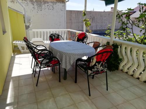 einen Tisch und Stühle auf dem Balkon eines Hauses in der Unterkunft Apartments with a parking space Vir - 11812 in Vir