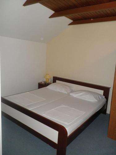 a bedroom with a bed with white sheets and a wooden ceiling at Apartments with parking space Orebic, Peljesac - 11834 in Orebić