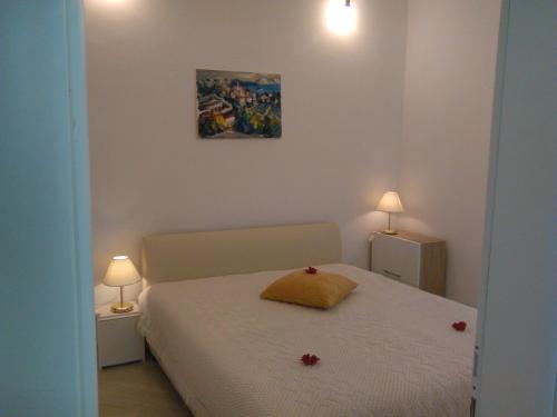 a bedroom with a bed with two lamps on both sides at Apartments by the sea Sreser, Peljesac - 11854 in Janjina