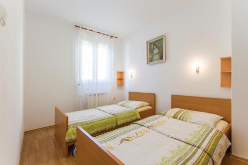 two beds in a room with a window at Apartments with a parking space Vinez, Labin - 11851 in Labin