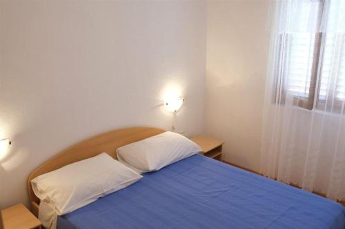 a bedroom with a blue bed with two pillows at Apartments with a parking space Rukavac, Vis - 11855 in Vis
