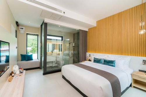 a bedroom with a large bed and a bathroom at Mila Kohlarn มิ-ลา เกาะล้าน in Pattaya