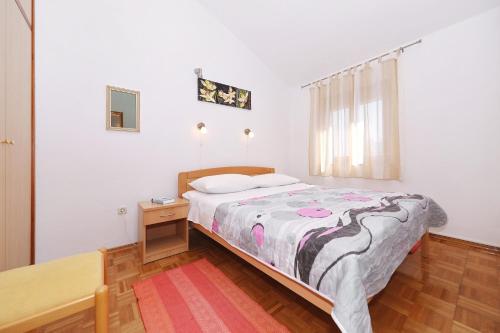 Schlafzimmer mit einem Bett, einem Tisch und einem Fenster in der Unterkunft Apartment Bozava 11896a in Božava