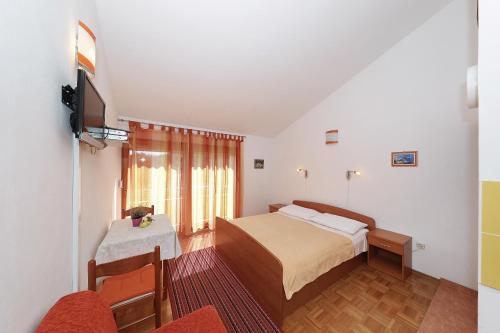 ein Hotelzimmer mit einem Bett und einem TV in der Unterkunft Apartments by the sea Bozava, Dugi otok - 11896 in Božava