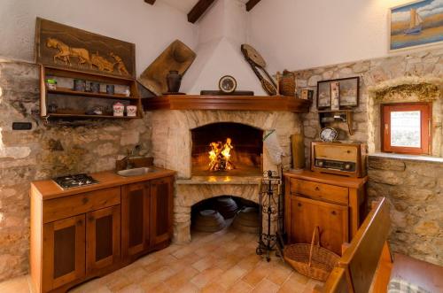 eine Küche mit einem Kamin in einer Steinwand in der Unterkunft Apartments with parking space Nin, Zadar - 11900 in Nin