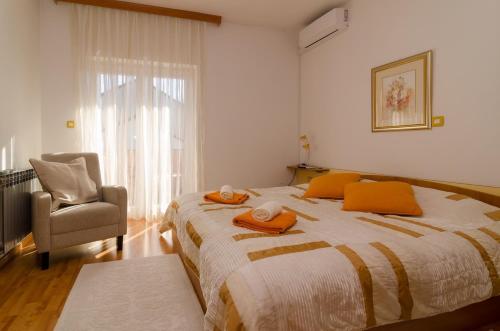 ein Schlafzimmer mit einem großen Bett mit orangefarbenen Handtüchern darauf in der Unterkunft Apartments with parking space Nin, Zadar - 11900 in Nin